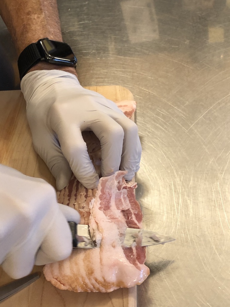 To trim all the surfaces of bacon that were in contact with plastic, we froze the bacon to make it easier to trim, then trimmed by hand.
